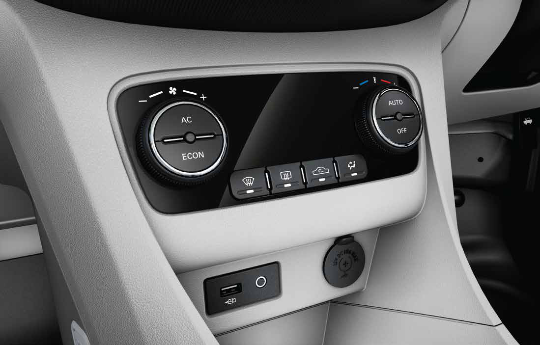 Tata Tigor EV — Fully automatic temperature control with rotary AC/ECON and AUTO dials, plus front USB port and 12V power outlet below