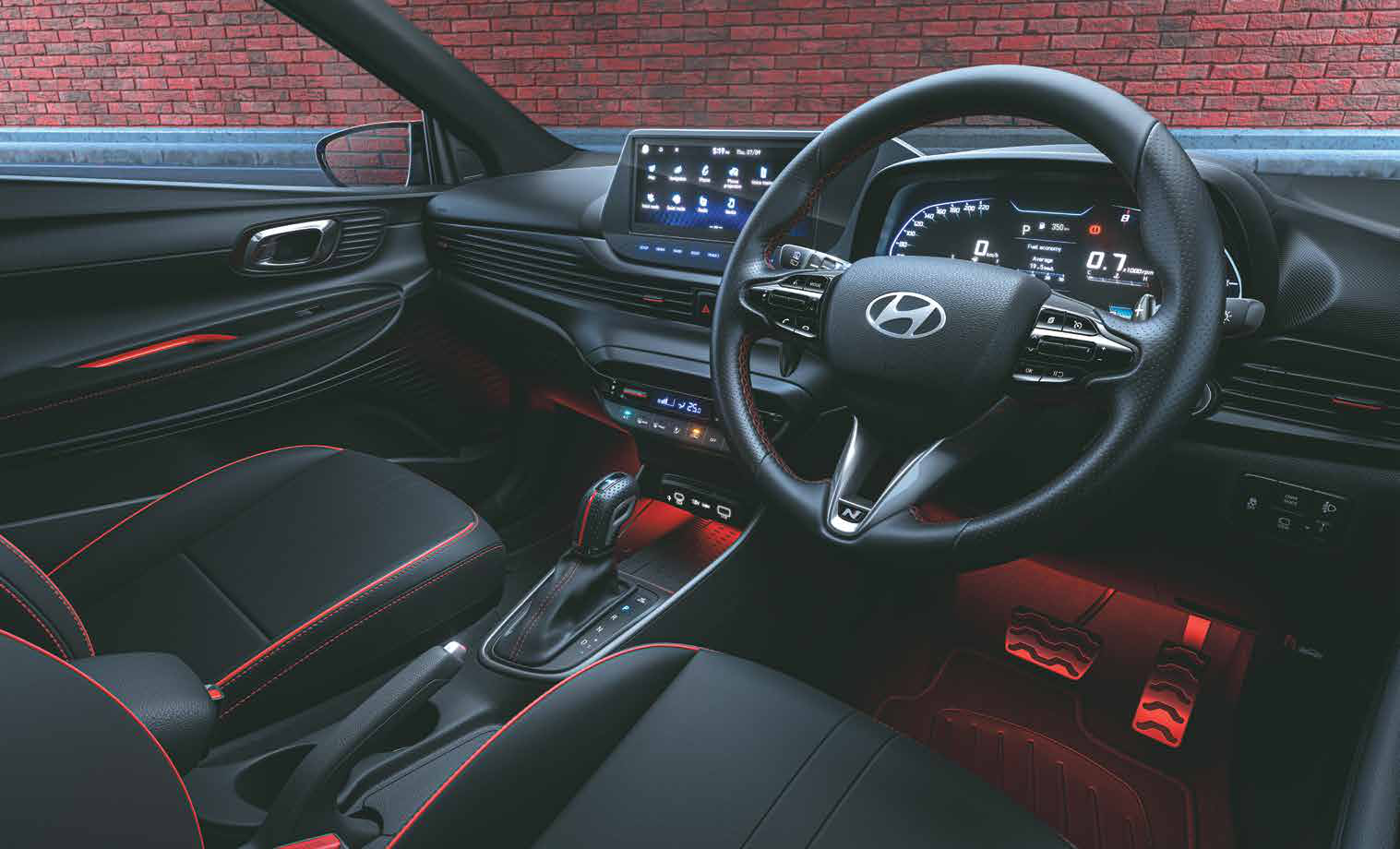 Hyundai i20 N Line — All-black sporty cockpit with red inserts and metal pedals
