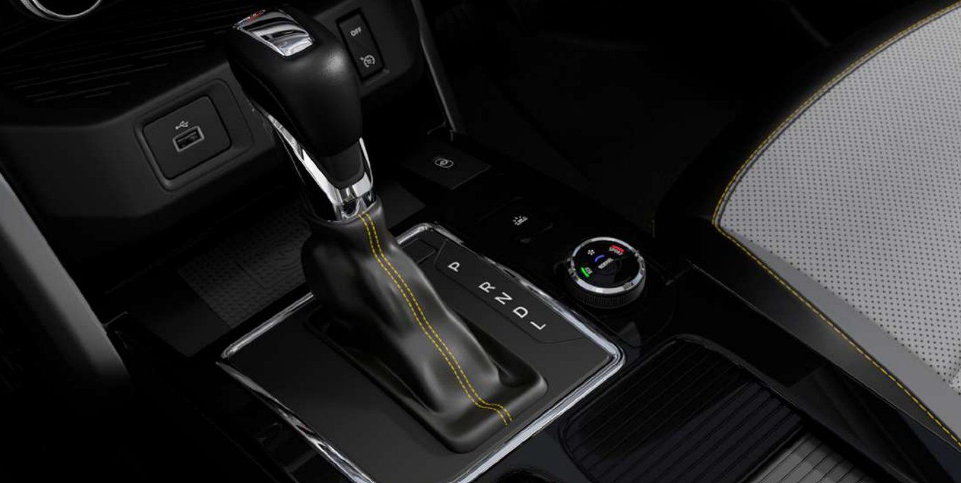Car interior showing automatic transmission shifter, steering wheel, and dashboard controls.