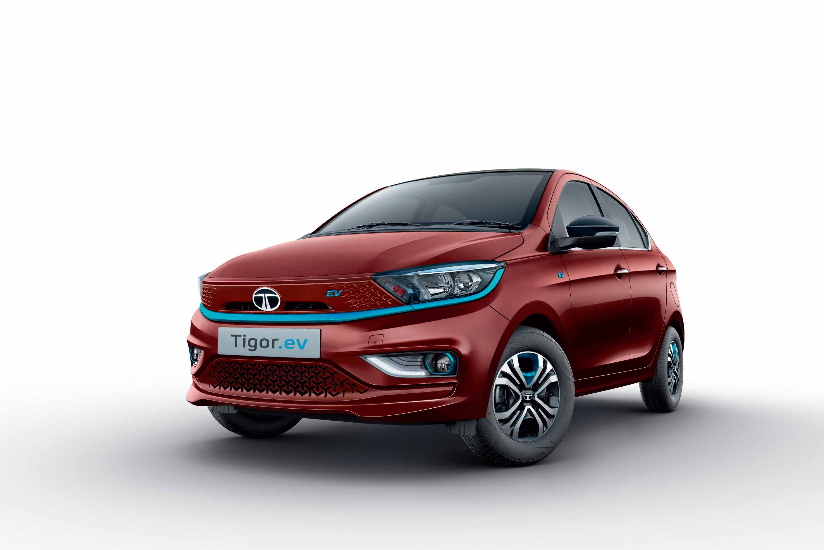 Tata Tigor EV — Dual-tone exterior with piano black contrast roof, closed EV front grille and signature blue accents on the humanity line, fog lamp housings and wheel trims