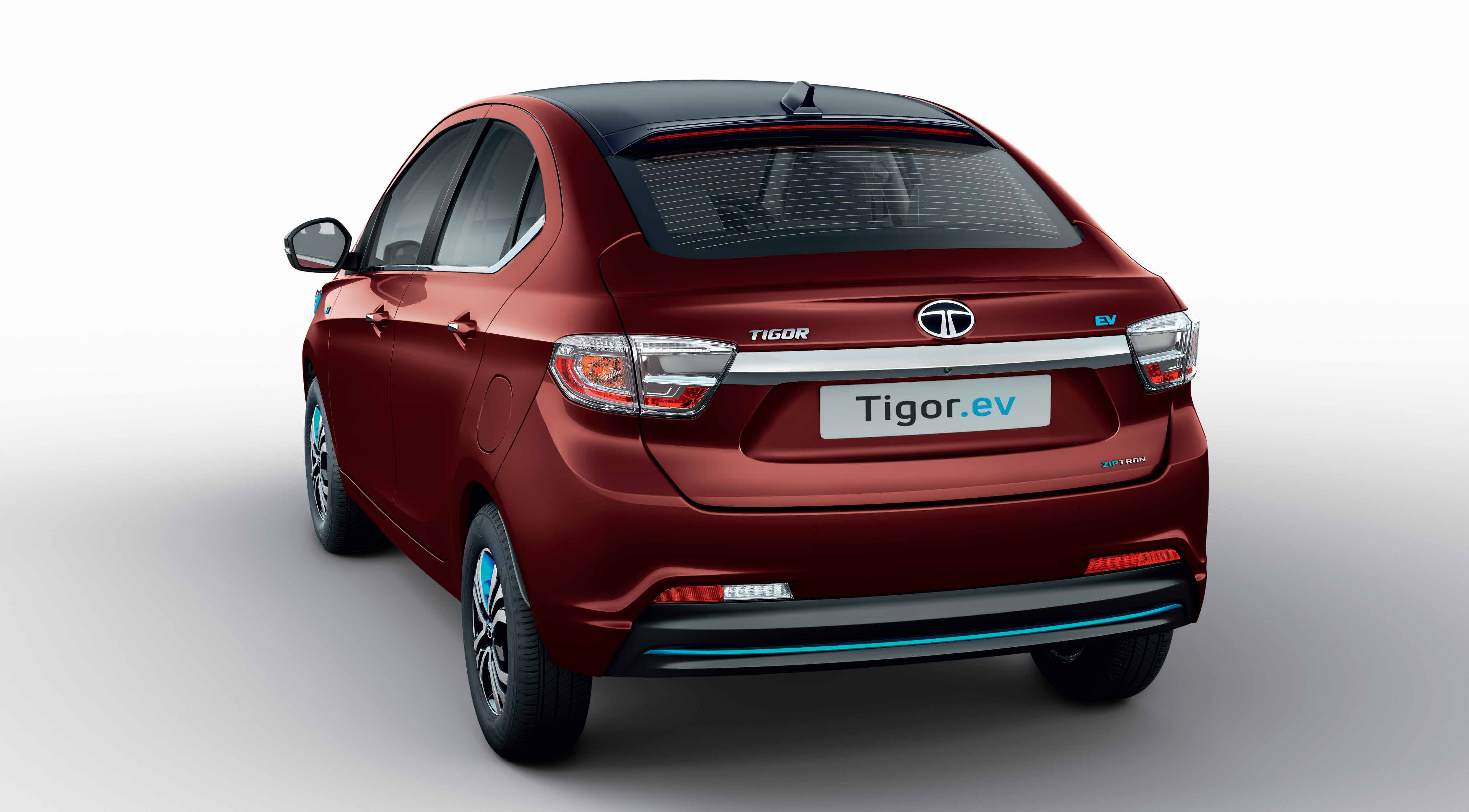 Tata Tigor EV — Tail lamps joined by a chrome boot garnish, with Ziptron badging, rear defogger and a blue accent strip on the rear bumper