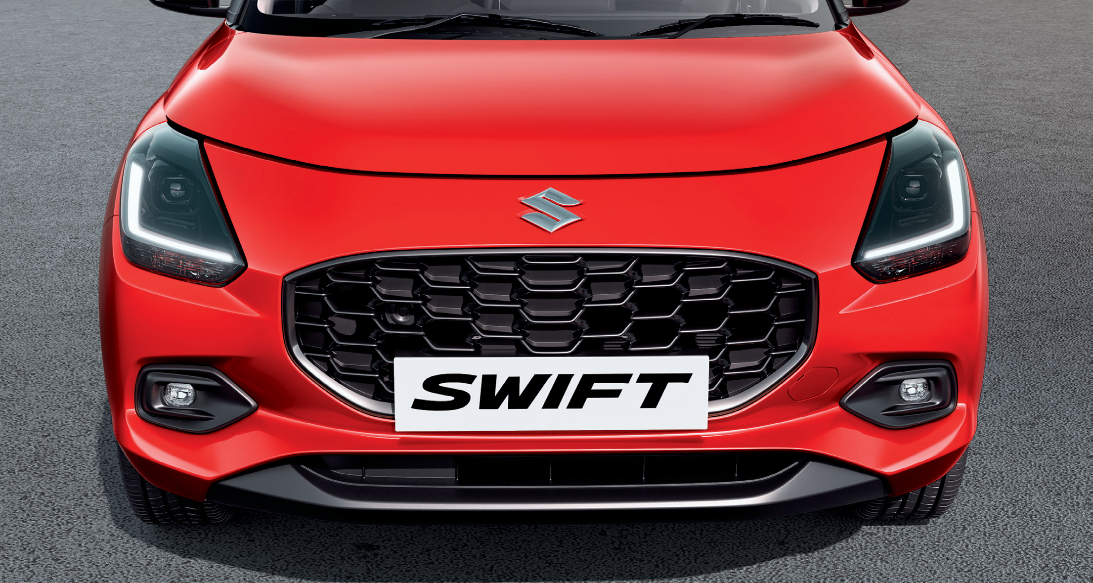 Maruti Suzuki Swift — Front fascia with glossy black honeycomb grille and Suzuki emblem