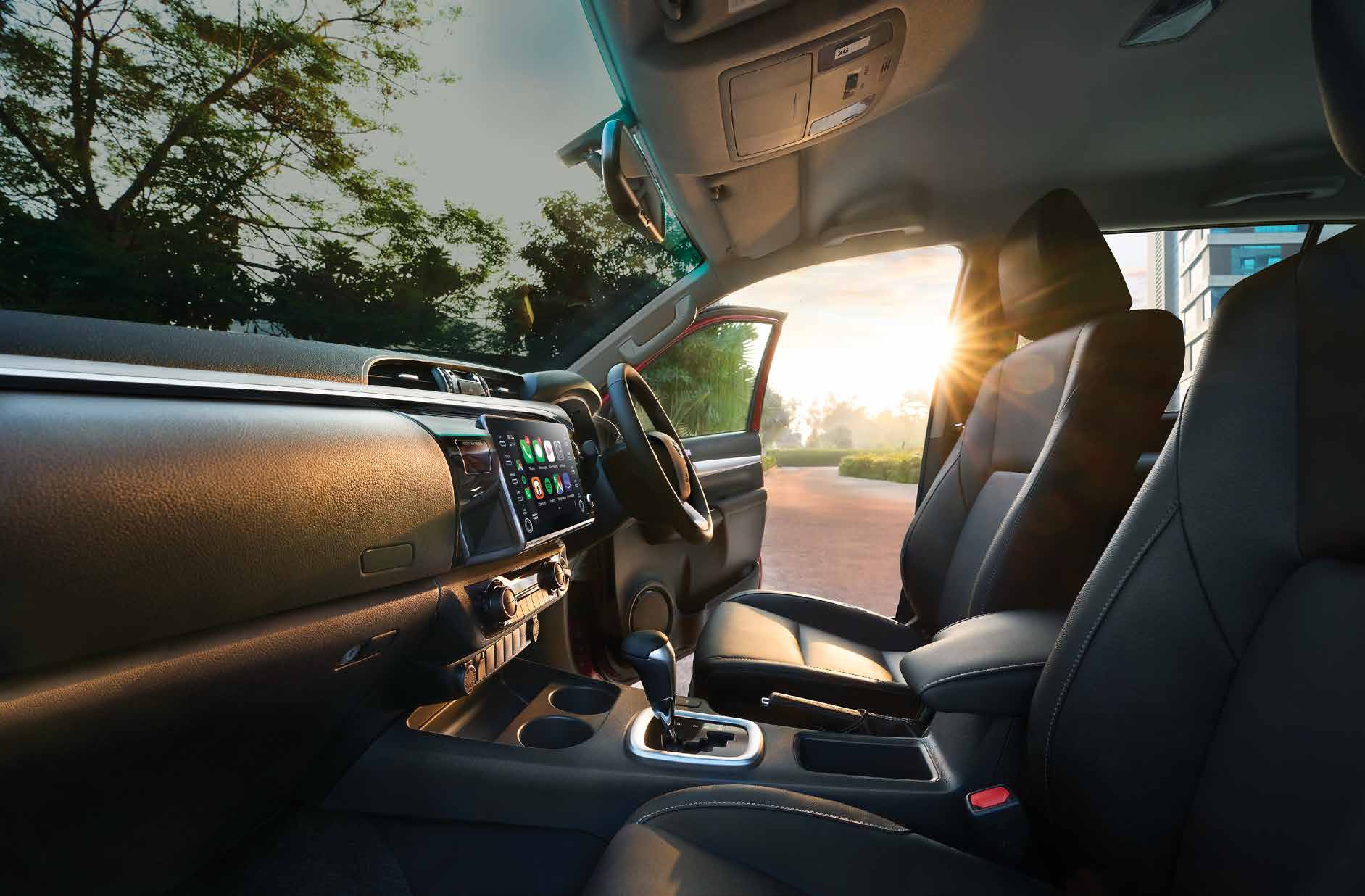 Toyota Hilux (2022-2025) — Black leather-trimmed seats with a floating touchscreen and automatic gear selector.