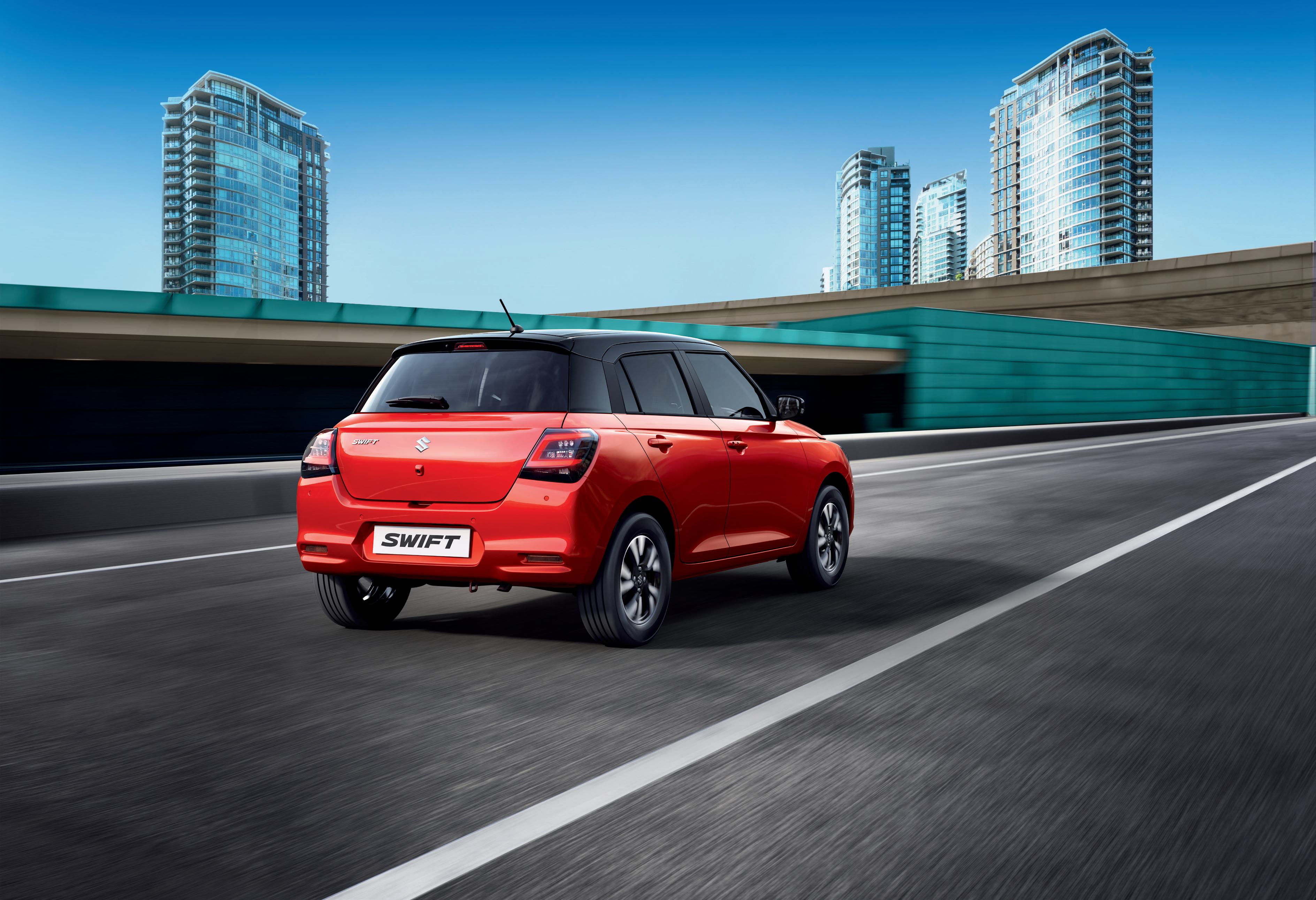 Maruti Suzuki Swift — Rear three-quarter profile showing the sporty stance and floating-roof design
