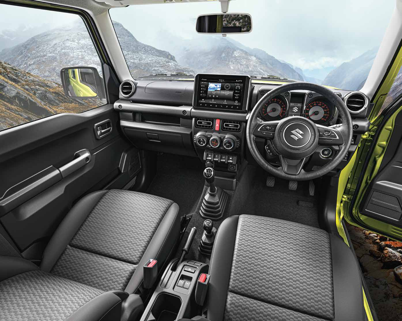 Maruti Suzuki Jimny — Upright dashboard with a floating touchscreen, analogue twin-dial cluster and manual gear lever.