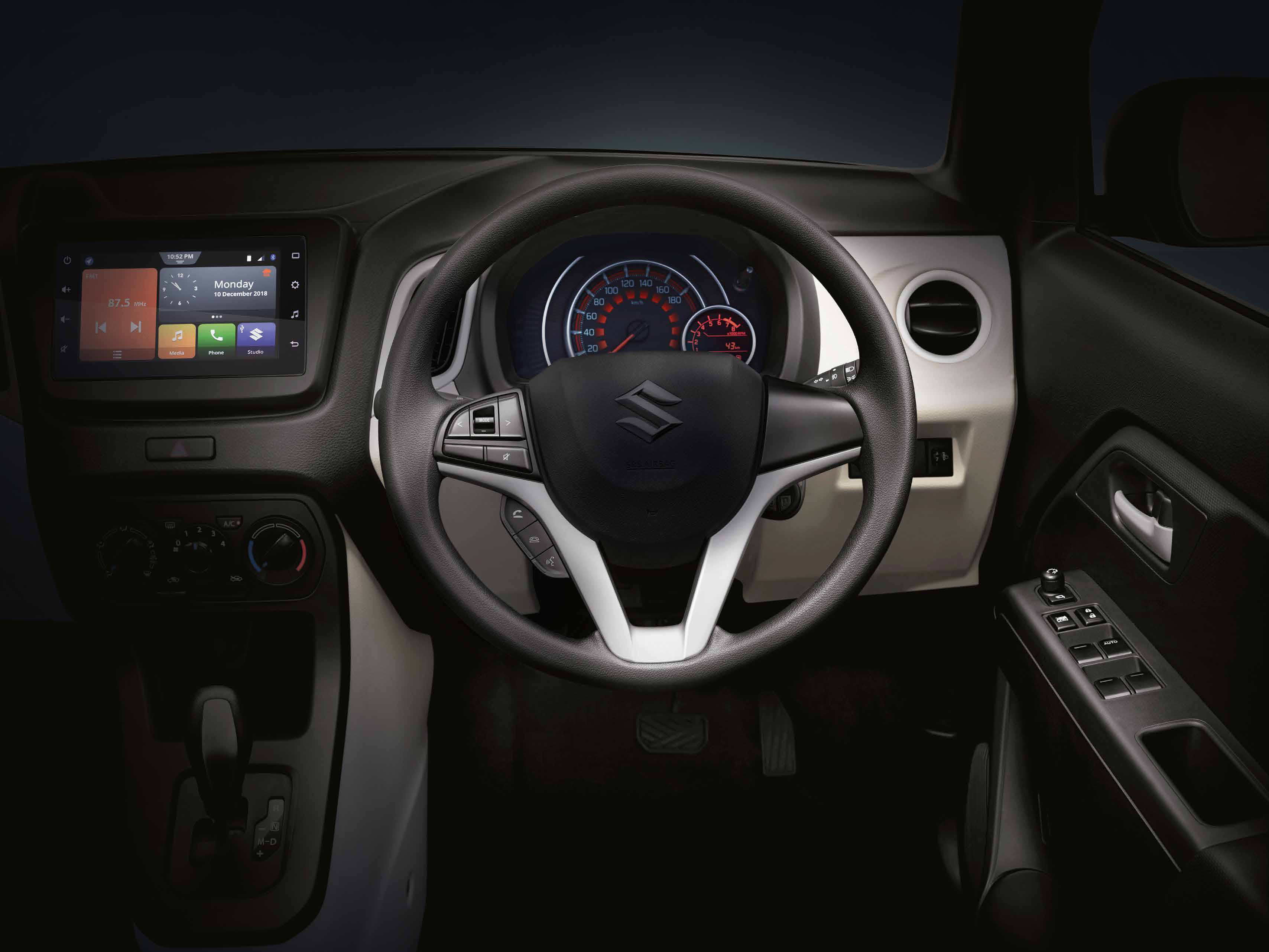 Maruti Suzuki Wagon R — Driver-focused dashboard with a floating touchscreen, twin-pod analogue instrument cluster, silver accents and steering-mounted controls.