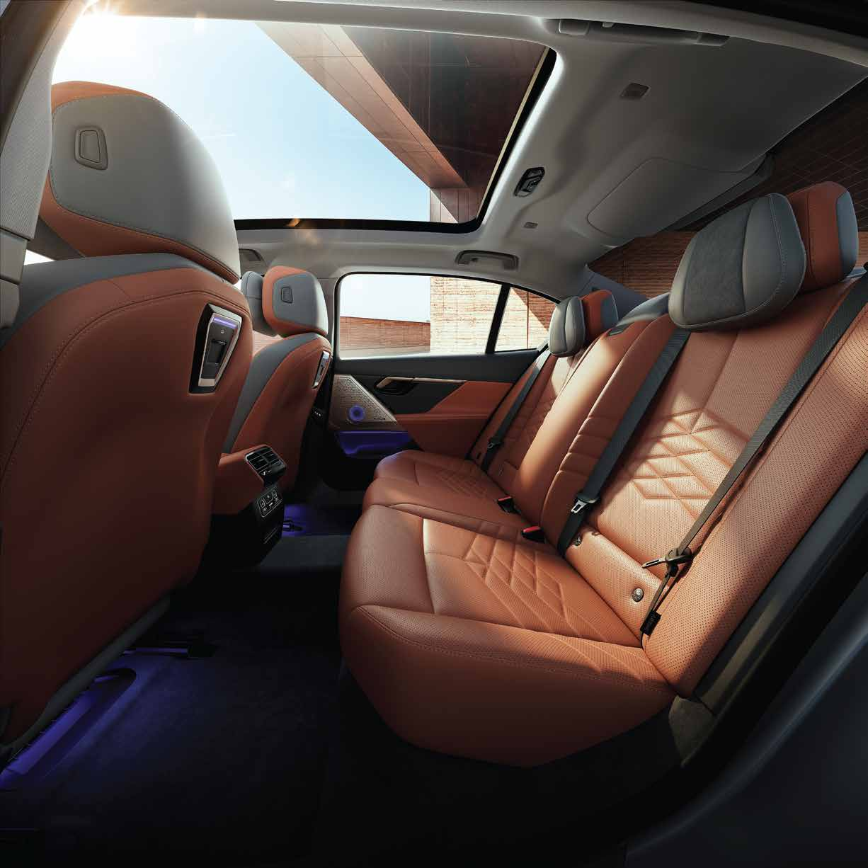 BMW 5 Series  — Rear seats in quilted vegan leather beneath the panoramic glassroof, with ambient footwell lighting
