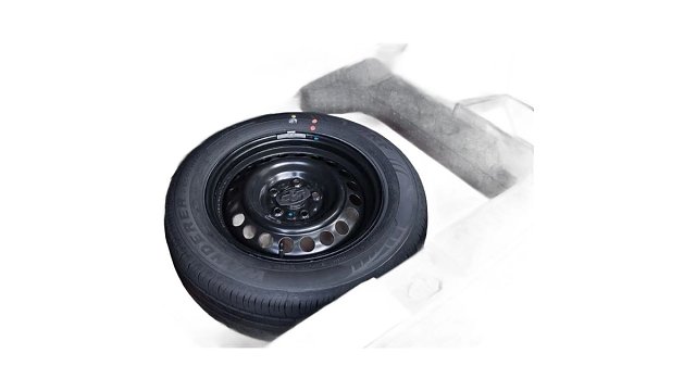 Black steel wheel with tire and gray protective cover on white background.