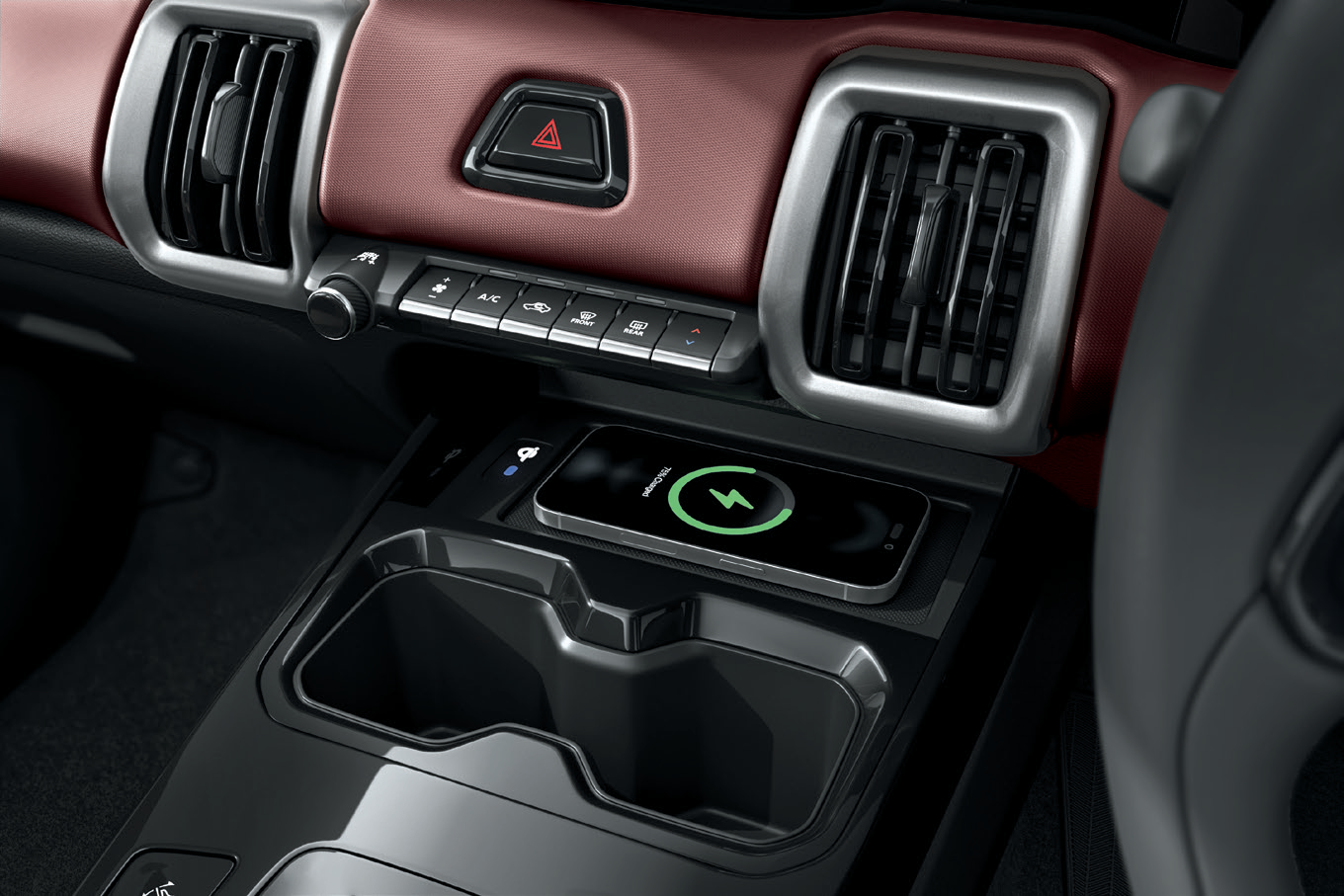 Maruti Suzuki e Vitara — Wireless smartphone charging pad in the centre console ahead of the cupholders.