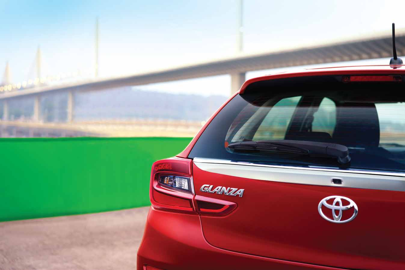 Toyota Glanza — LED tail lamps flanking the Glanza badge, with a rear wiper on the sloping tailgate.