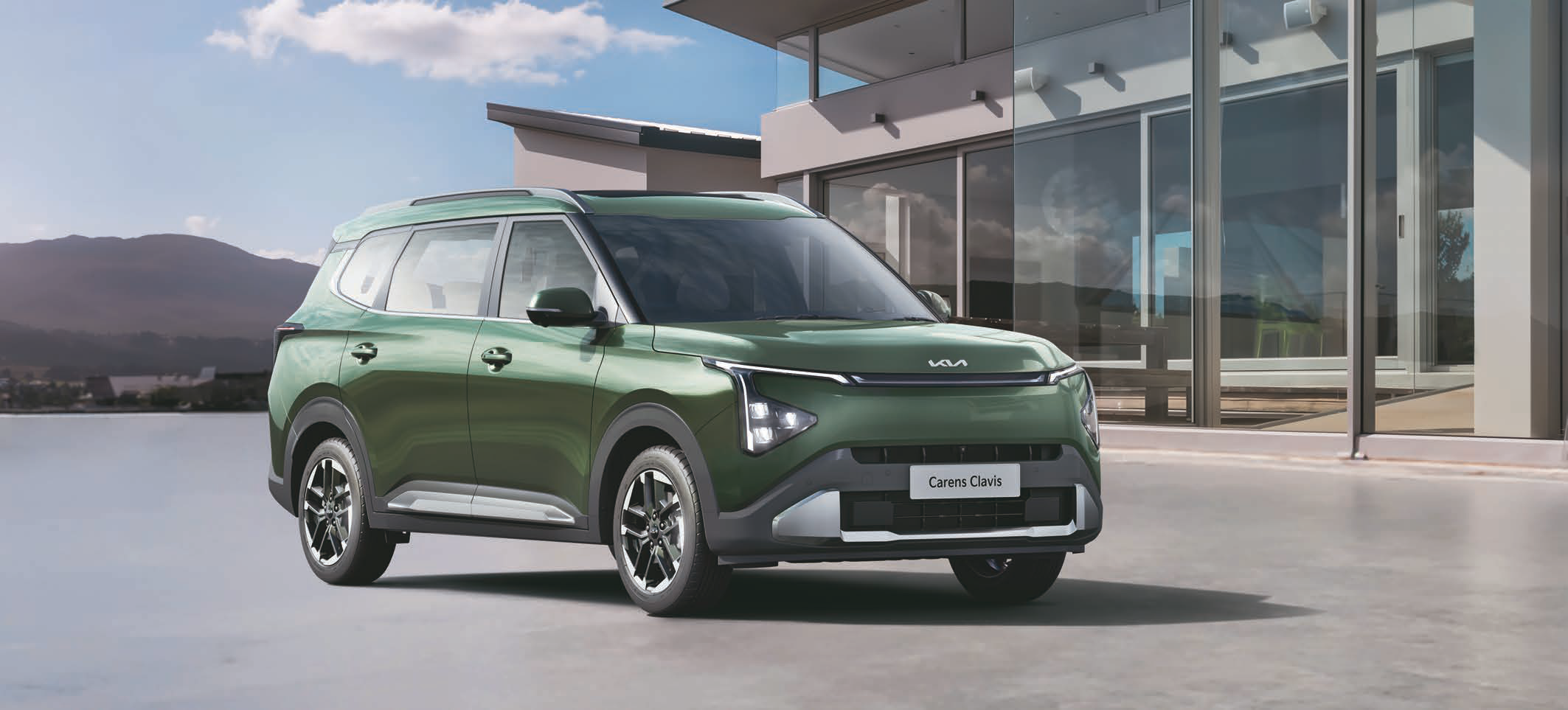 Kia Carens Clavis — Bold three-quarter stance with roof rails and machined dual-tone alloy wheels