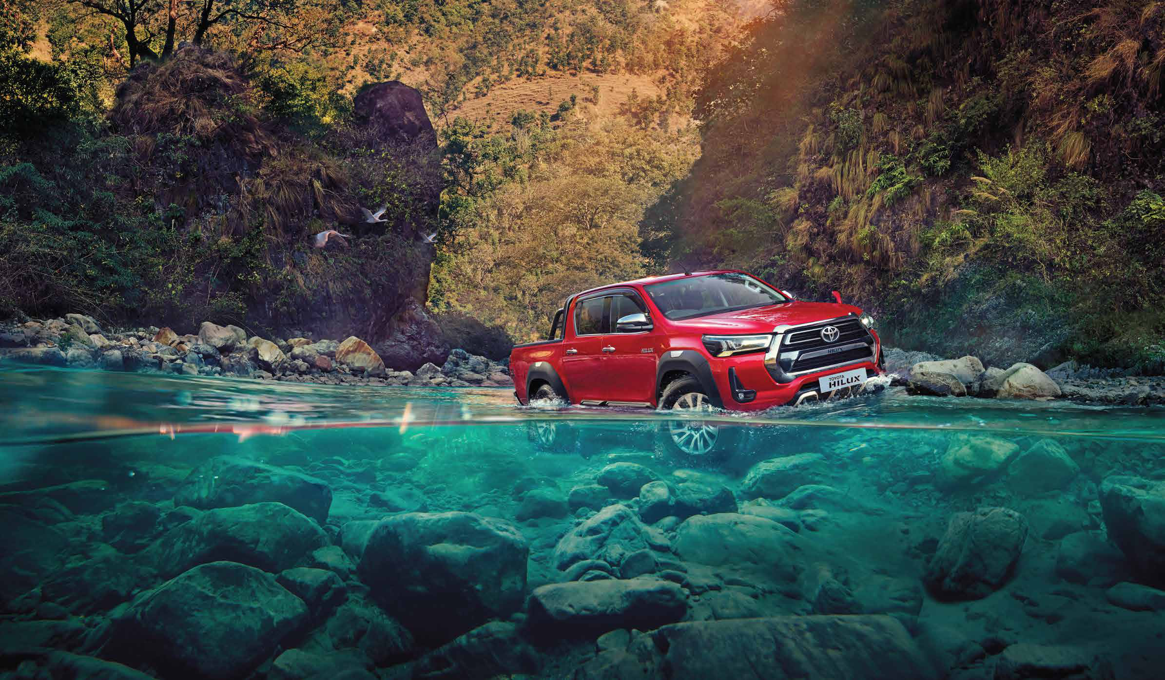 Toyota Hilux (2022-2025) — Wading through a rocky river crossing.